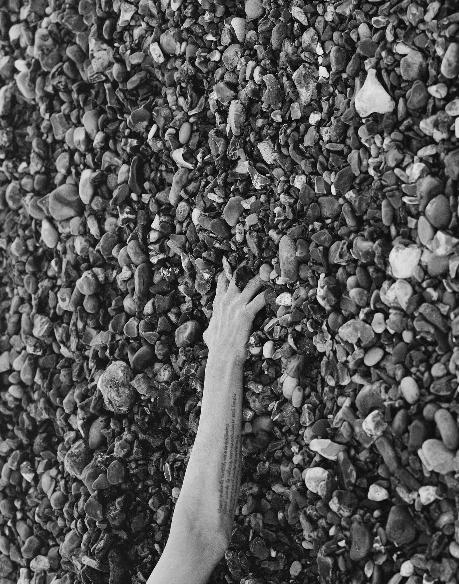 Ezra Evans - Untitled #5 the south west collective of photography hand in the stones on the beach